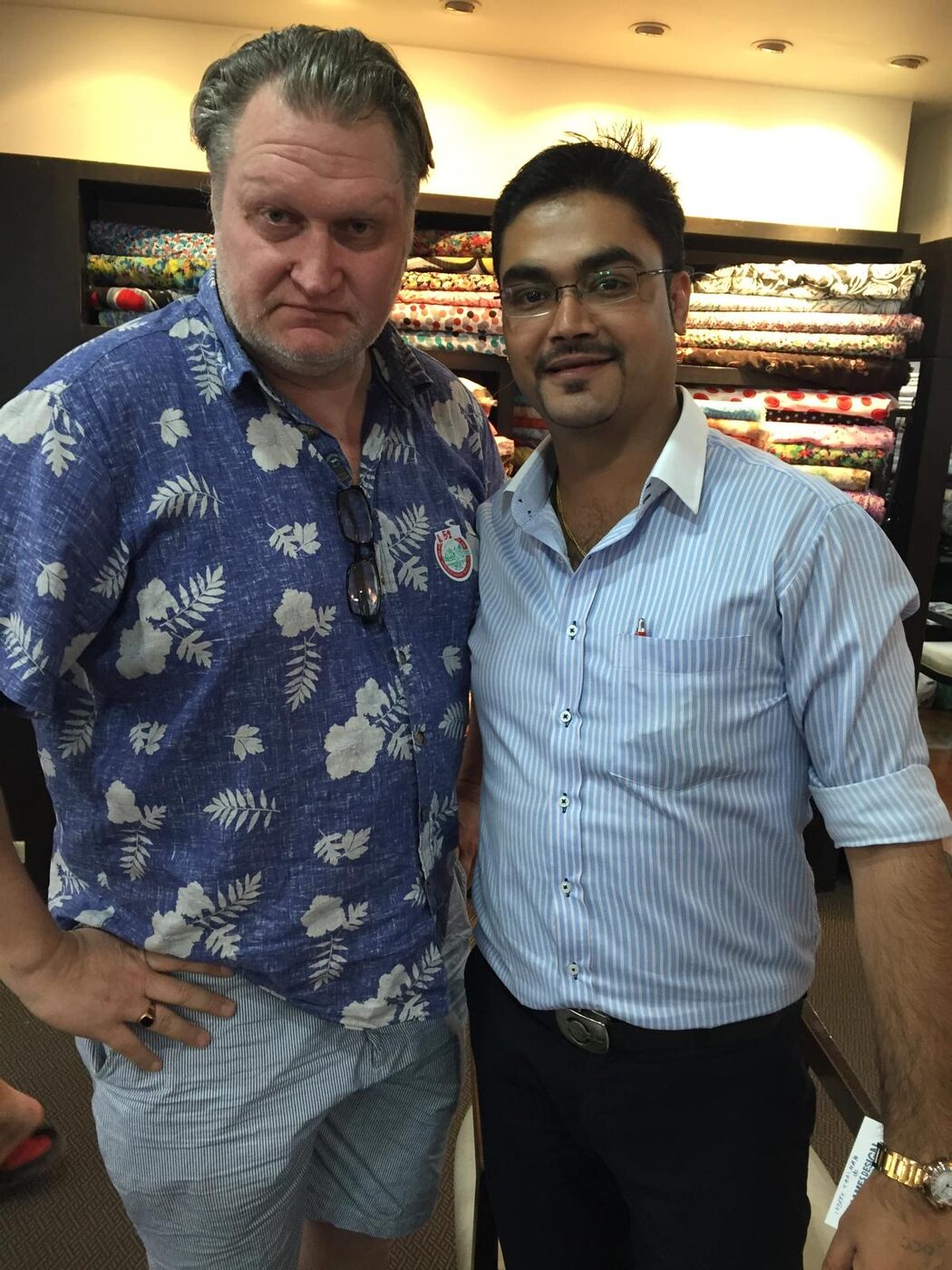A client with the tailor among the fabric shelves